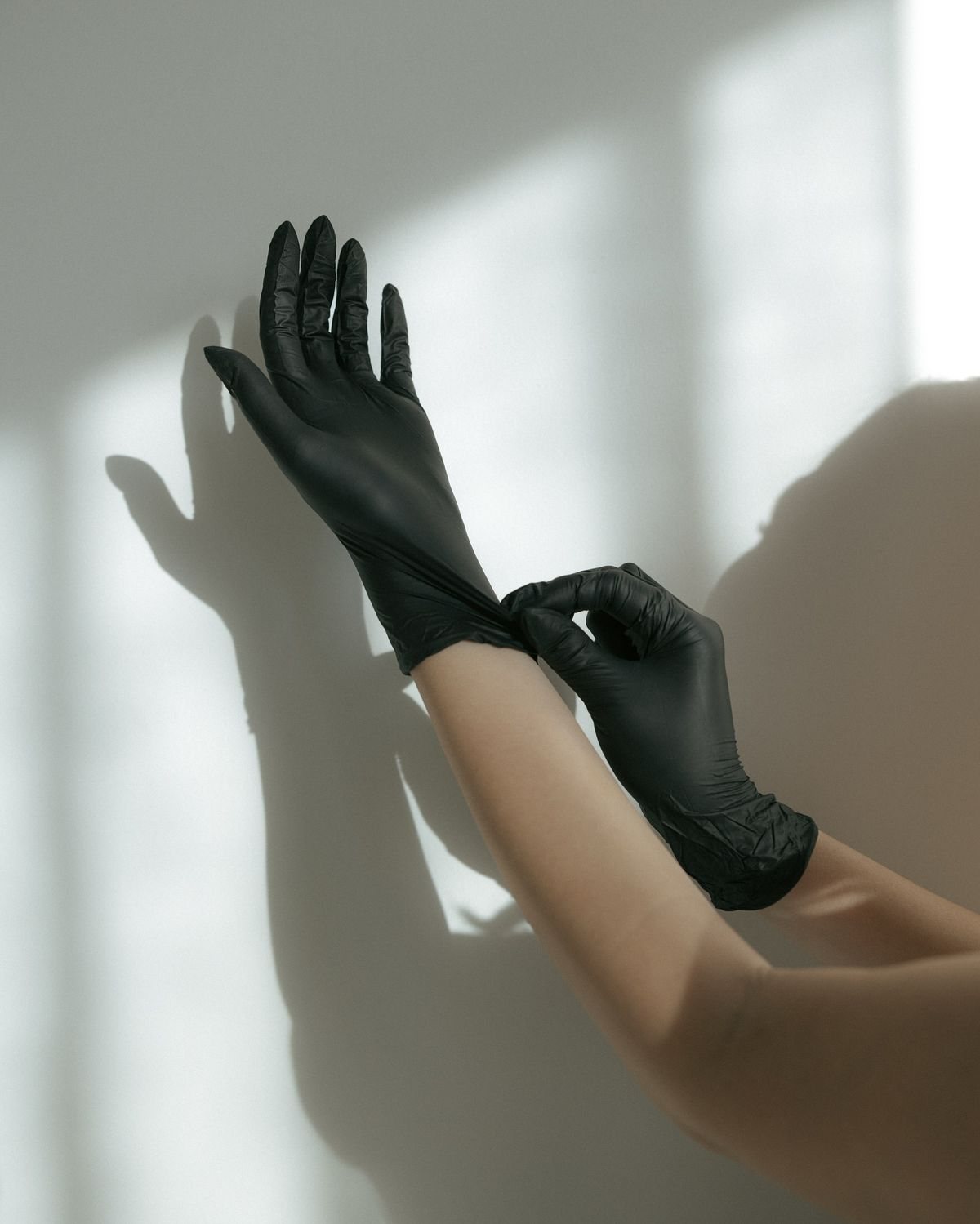 Manos colocándose guantes de nitrilo antes de un procedimiento
